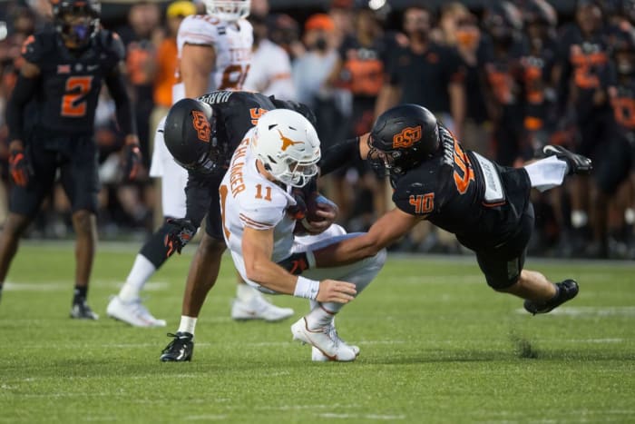 Brock Martin (40) and Devin Harper (behind) combine to stop Texas quarterback Sam Ehlinger.